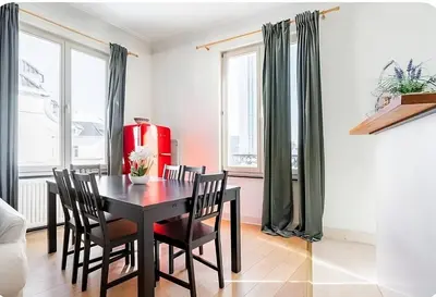 a dining room with a black table and chairs at Brussels Royal - Freedom Square in Brussels