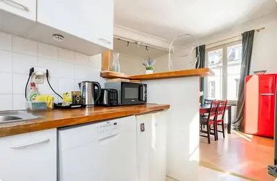 a kitchen with white appliances and a red refrigerator at Brussels Royal - Freedom Square in Brussels