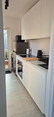 a kitchen with white cabinets and a stove top oven at Cosy flat in Antwerp