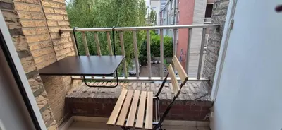 a table and a bench on a balcony at Cosy flat in Antwerp