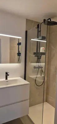 a bathroom with a shower and a sink and a mirror at Cosy flat in Antwerp