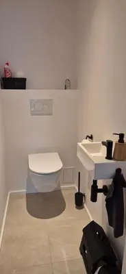 a bathroom with a white toilet and a sink at Cosy flat in Antwerp