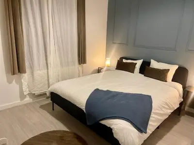 a bedroom with a bed with a blue blanket on it at Le longue vie in Brussels