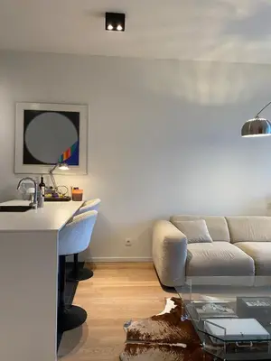a living room with a couch and a table at Designer Apartment on the Skyline of Brussels in Brussels