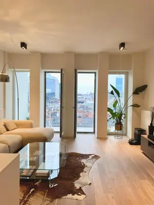 a living room with a couch and a glass table at Designer Apartment on the Skyline of Brussels in Brussels