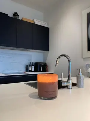 a candle sitting on a kitchen counter next to a sink at Designer Apartment on the Skyline of Brussels in Brussels