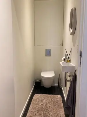 a bathroom with a white toilet and a sink at Designer Apartment on the Skyline of Brussels in Brussels