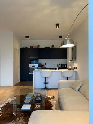 a living room with a couch and a kitchen at Designer Apartment on the Skyline of Brussels in Brussels
