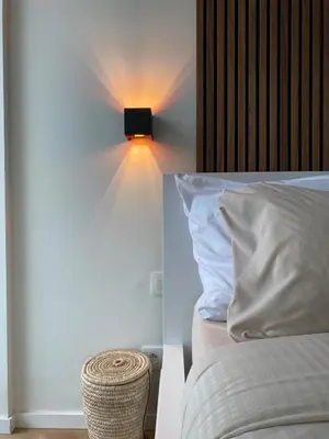 a bedroom with a bed with a light on the wall at Designer Apartment on the Skyline of Brussels in Brussels