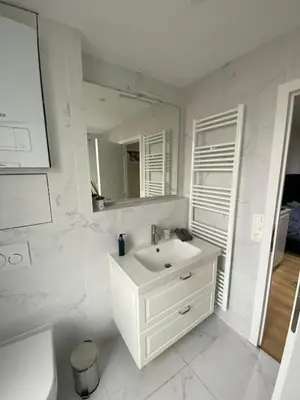 a white bathroom with a sink and a mirror at Grote Markt suite 3 in Antwerp