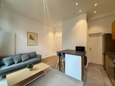 a living room with a blue couch and a table at Urban Nest - Brussels in Brussels