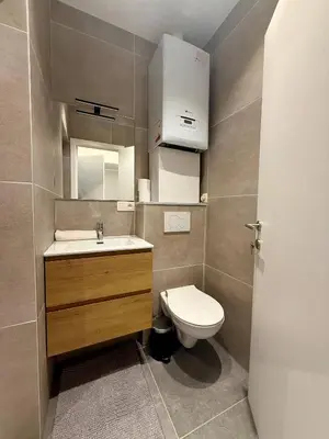 a small bathroom with a toilet and a sink at The Modern Nest - Jourdan in Brussels