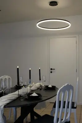 a dining room with a table with chairs and a light fixture at Diesters huisje in Diest