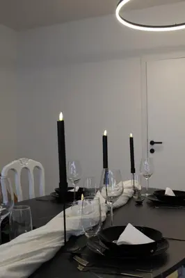 a dining room table with a black table cloth and candles at Diesters huisje in Diest