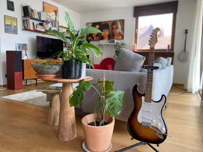 a living room with a guitar and a couch at Spacious & cosy apartment center in Ghent