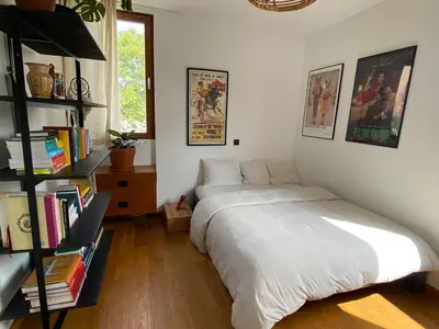 a bedroom with a bed and a book shelf with books at Spacious & cosy apartment center in Ghent