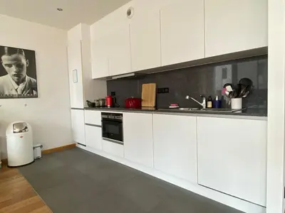a kitchen with white cabinets and a counter top at Spacious & cosy apartment center in Ghent