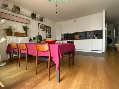 a dining room with a pink table and chairs at Spacious & cosy apartment center in Ghent