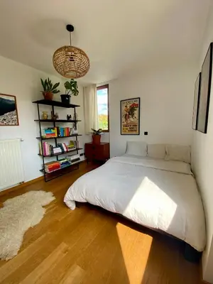 a bedroom with a large bed and a book shelf at Spacious & cosy apartment center in Ghent