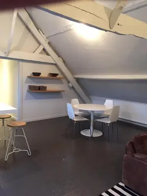 a room with a table and chairs in a attic at Vakantie Appartement De Sneppelhoeve in Wuustwezel