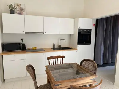 a kitchen with white cabinets and a wooden table at T' Suikerklontje in Antwerp