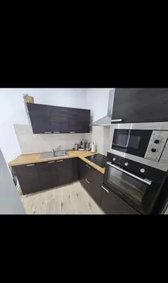 a kitchen with black cabinets and a stove top oven at Studio cozy et charmant in Brussels