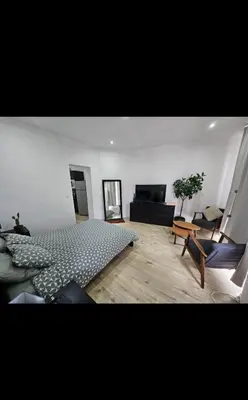 a bedroom with a bed and a living room at Studio cozy et charmant in Brussels