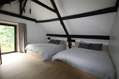 two beds in a room with a window at Huisje Nostalgie in Laakdal