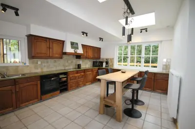 a kitchen with wooden cabinets and a wooden table at Huisje Nostalgie in Laakdal