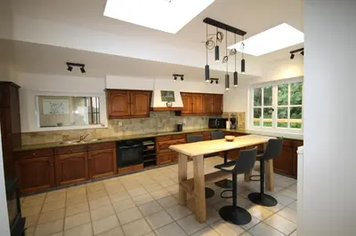 a kitchen with wooden cabinets and a wooden table at Huisje Nostalgie in Laakdal