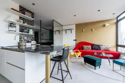 a kitchen and living room with a red couch at Ecstatic Living Ixelles, Luxury in the European Quarter in Brussels