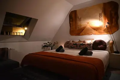 a bedroom with a large bed with a large painting on the wall at Vintage Soul, Green Vibes, Heart of the City in Brussels