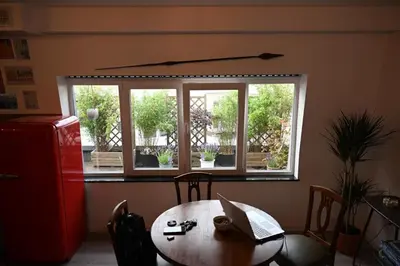 a dining room with a table and a window at Vintage Soul, Green Vibes, Heart of the City in Brussels
