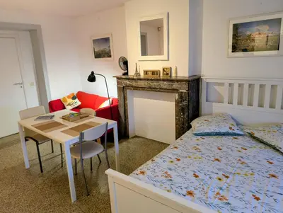 a bedroom with a bed and a desk and a table at Central and convenient studio near supermarkets and public transports in Brussels
