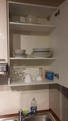 a kitchen sink with plates and dishes on a shelf at Central and convenient studio near supermarkets and public transports in Brussels