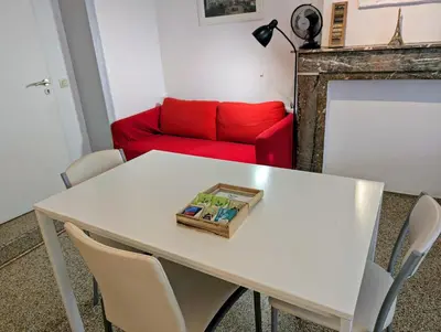 a living room with a white table with a red couch at Central and convenient studio near supermarkets and public transports in Brussels