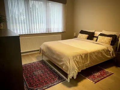 a bedroom with a bed and a window and a rug at Modern 2-Bed Urban Apartment in Brussels