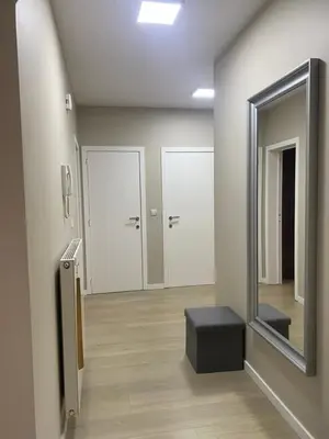 a hallway with a mirror and a stool in a room at Modern 2-Bed Urban Apartment in Brussels