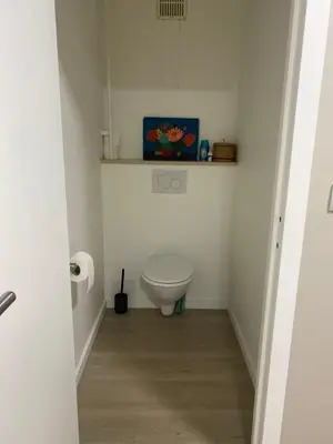 a white bathroom with a toilet in a room at Modern 2-Bed Urban Apartment in Brussels