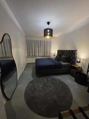 a bedroom with a bed and a couch and a rug at Nord Center 1D in Brussels