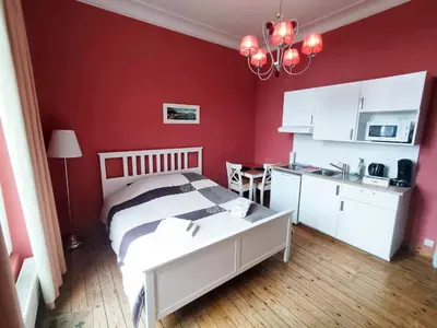 a bedroom with a bed and a red wall at Charming studio apartment with terrace near Mérode in Brussels