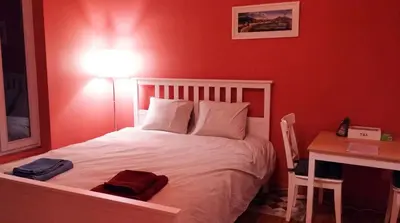 a bedroom with a bed with a desk and a lamp at Charming studio apartment with terrace near Mérode in Brussels
