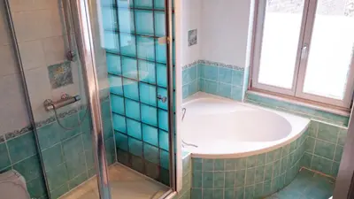 a bathroom with a shower with a tub and a sink at Charming studio apartment with terrace near Mérode in Brussels
