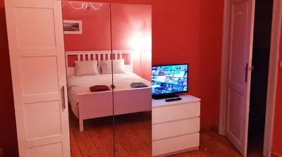 a bedroom with a bed and a desk with a computer at Charming studio apartment with terrace near Mérode in Brussels