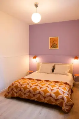 a bedroom with a large bed with purple walls at Chaleureux appartement aux Marolles in Brussels