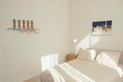 a white bedroom with a bed and a picture on the wall at Chaleureux appartement aux Marolles in Brussels