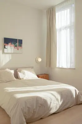 a bedroom with a large white bed with a window at Chaleureux appartement aux Marolles in Brussels