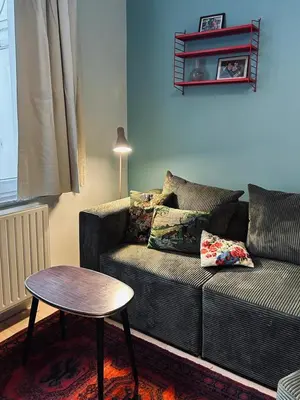 a living room with a couch and a table at Chaleureux appartement aux Marolles in Brussels