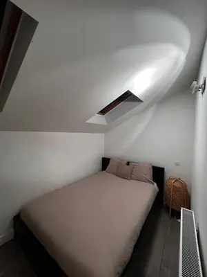 a bed in a small room with a ceiling at 3 bedroom Loft Antwerp in Antwerp