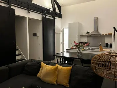 a living room with a couch and a kitchen at 3 bedroom Loft Antwerp in Antwerp